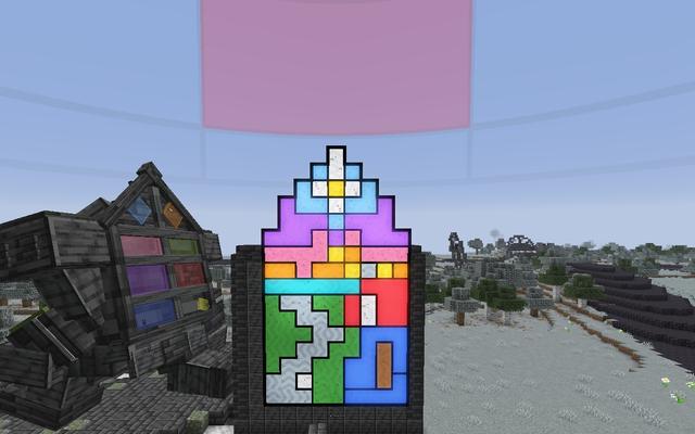 The same window lit up in purple, pink, gold, green and blue glass